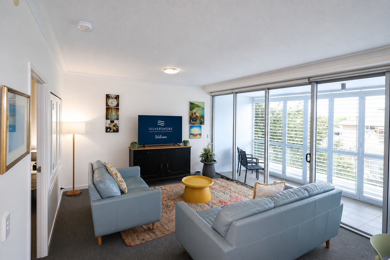 Een moderne woonkamer met een bank, een salontafel en een flatscreen televisie.