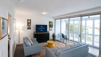 Een moderne woonkamer met een bank, een salontafel en een flatscreen televisie.