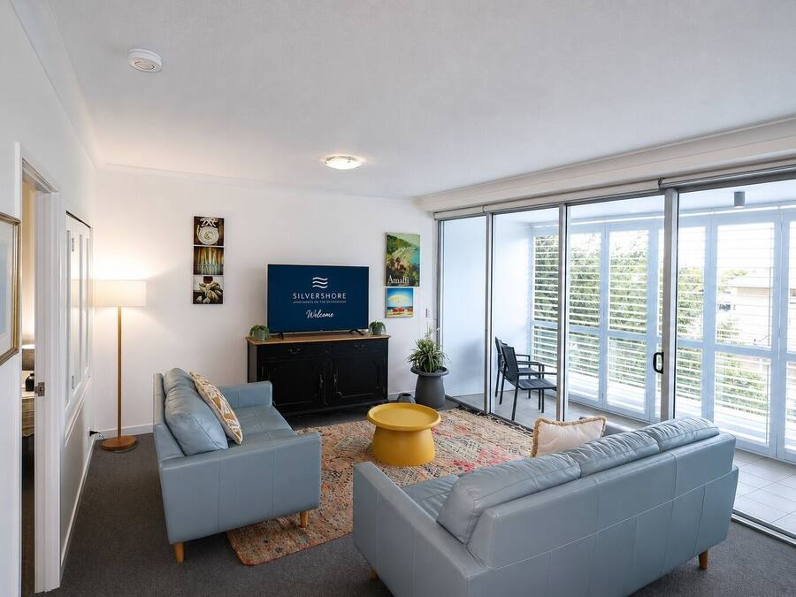 Een moderne woonkamer met een bank, een salontafel en een flatscreen televisie.