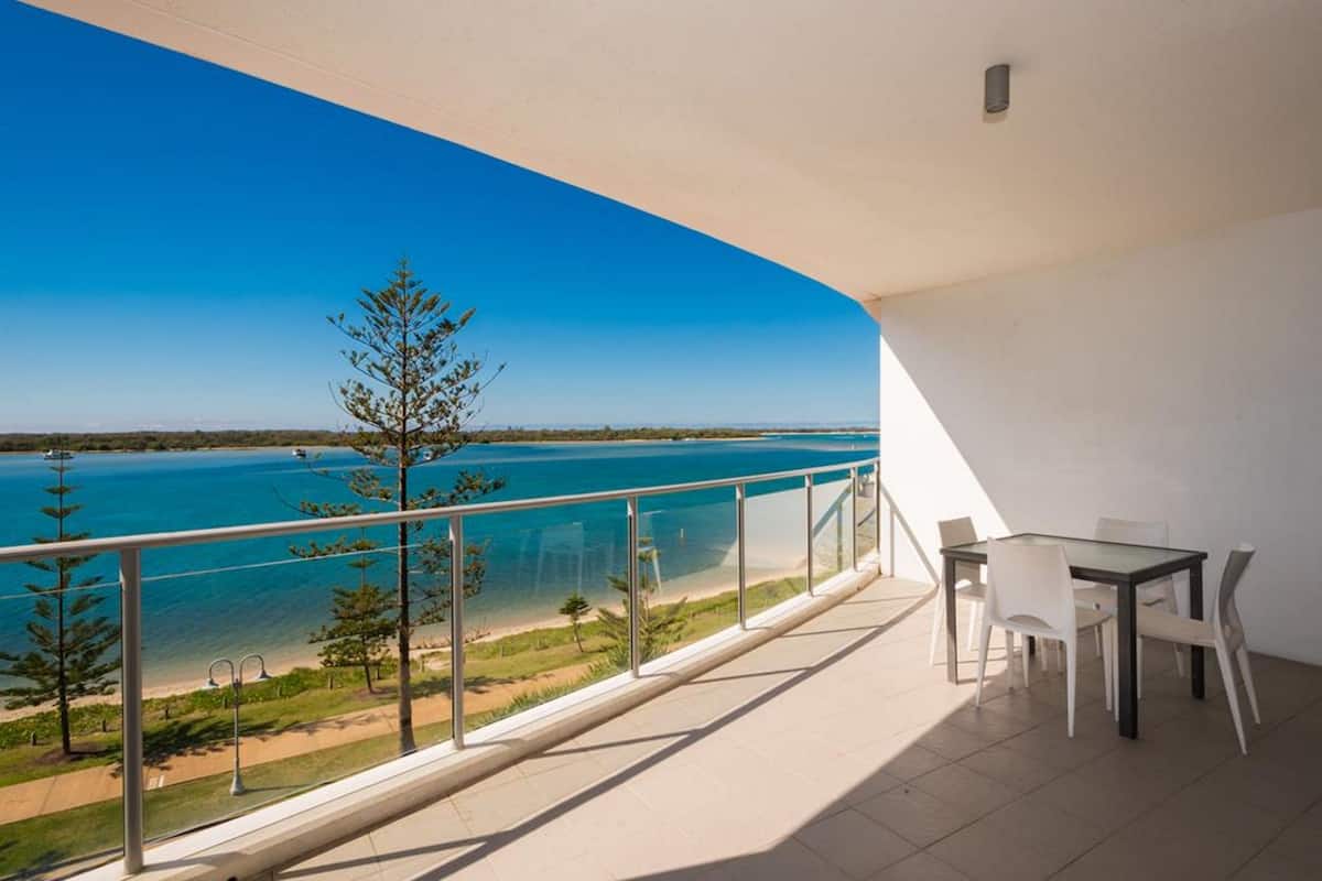 Ein Balkon mit freiem Blick auf Strand und Meer.