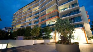 Un hôtel à plusieurs étages doté de balcons, d’une cour aménagée et d’une architecture moderne.