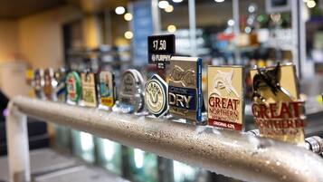 Un bar proposant une variété de bières à la pression, notamment des marques comme Carlton Dry et Great Northern Brewing Co.