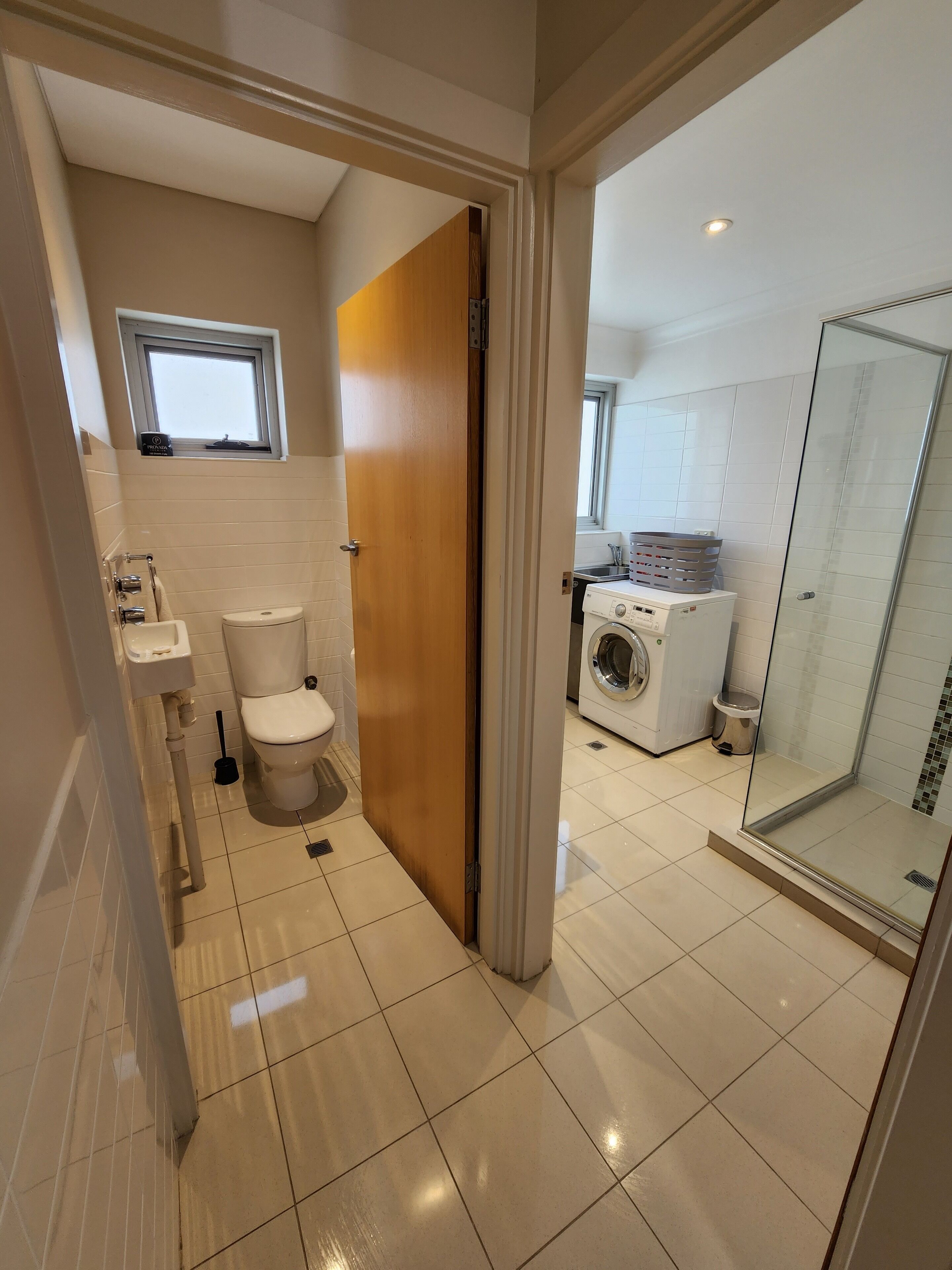 A modern bathroom with a toilet, sink, and washing machine.