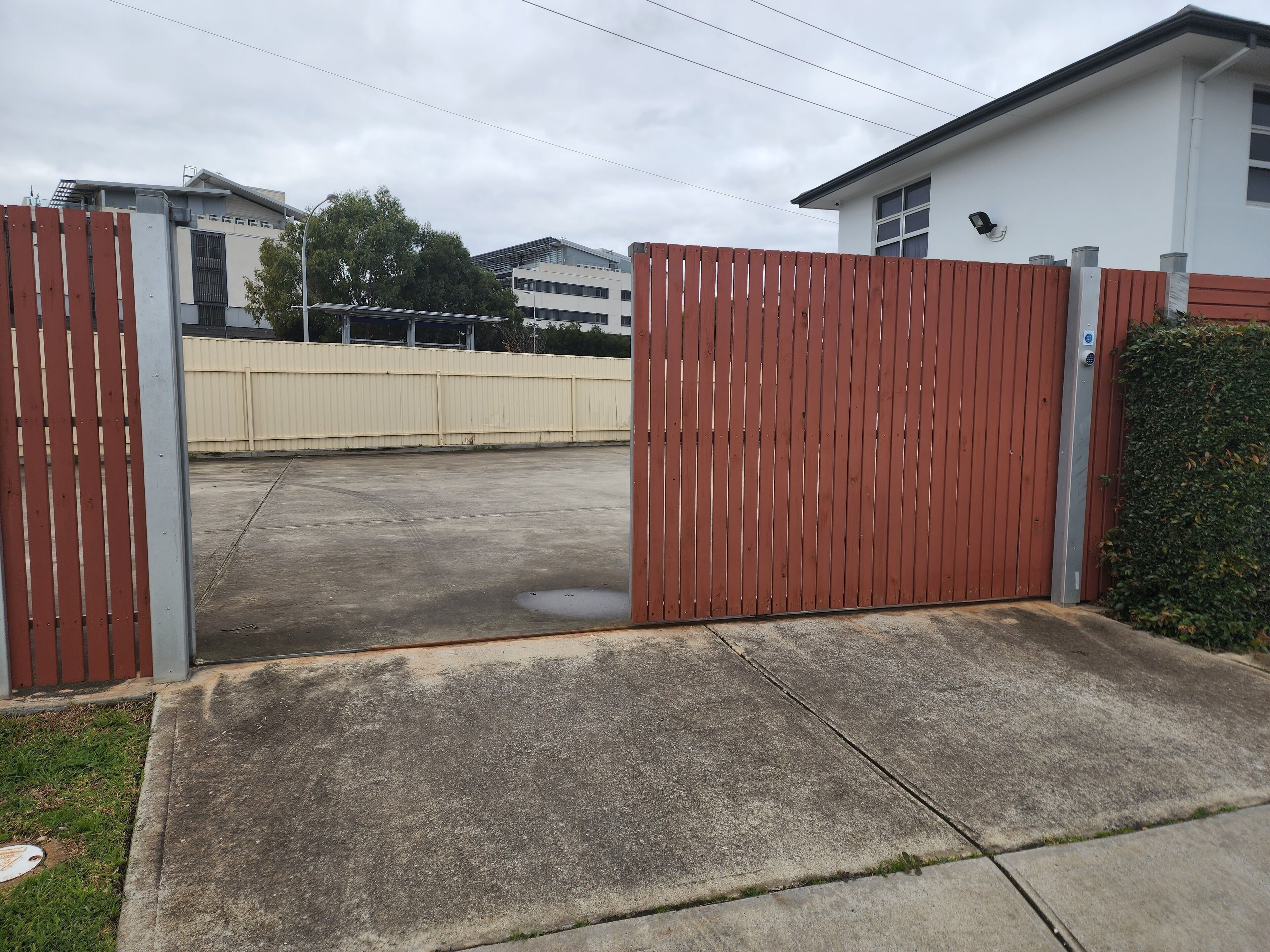 A gated parking area with a concrete surface and a metal fence.