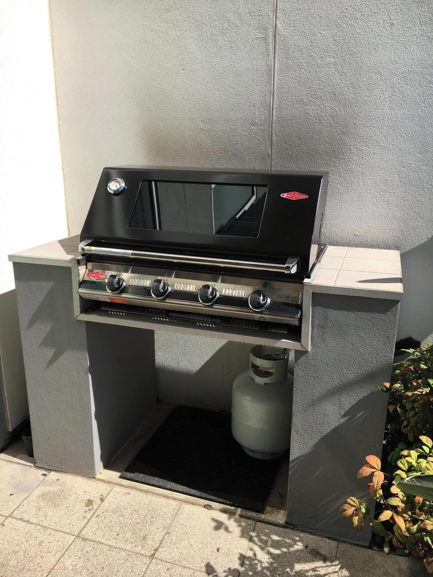 Un barbecue à gaz d’extérieur doté de quatre brûleurs, d’un écran numérique et d’une finition en acier inoxydable.