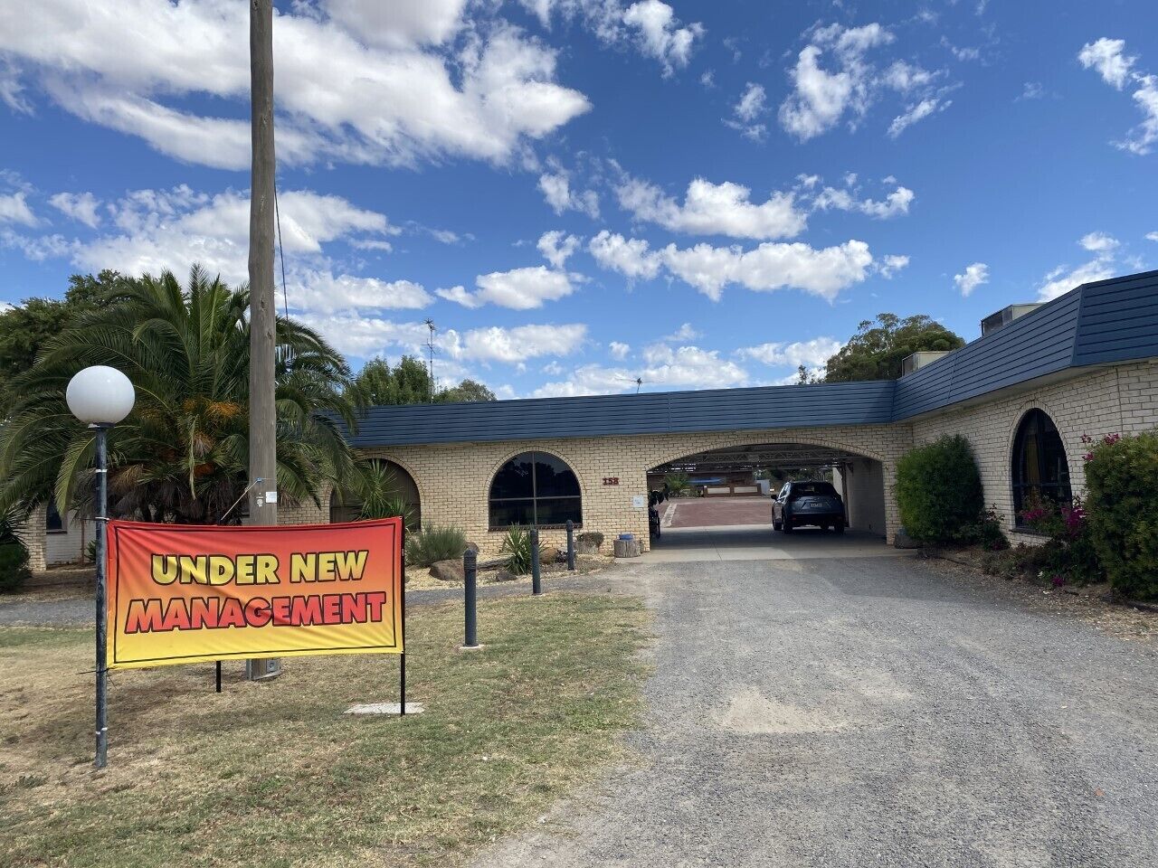 A building with a sign stating "UNDER NEW MANAGEMENT" in front.