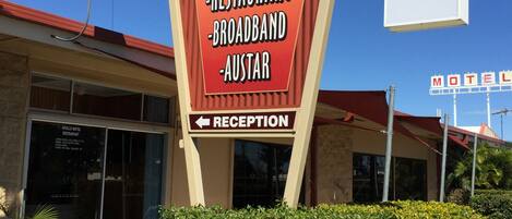 Placa de motel com comodidades incluindo restaurante, banda larga e a marca AUSTAR.