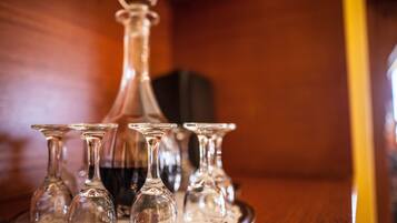 A tray with several clear wine glasses and a decanter on a wooden table.