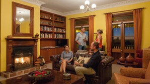 Un salon chaleureux avec une cheminée, des étagères à livres et des fauteuils confortables.