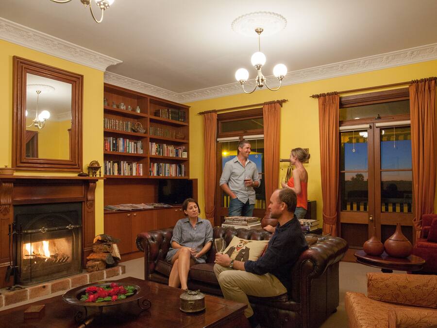 Una sala de estar acogedora con chimenea, estanterías y asientos cómodos.