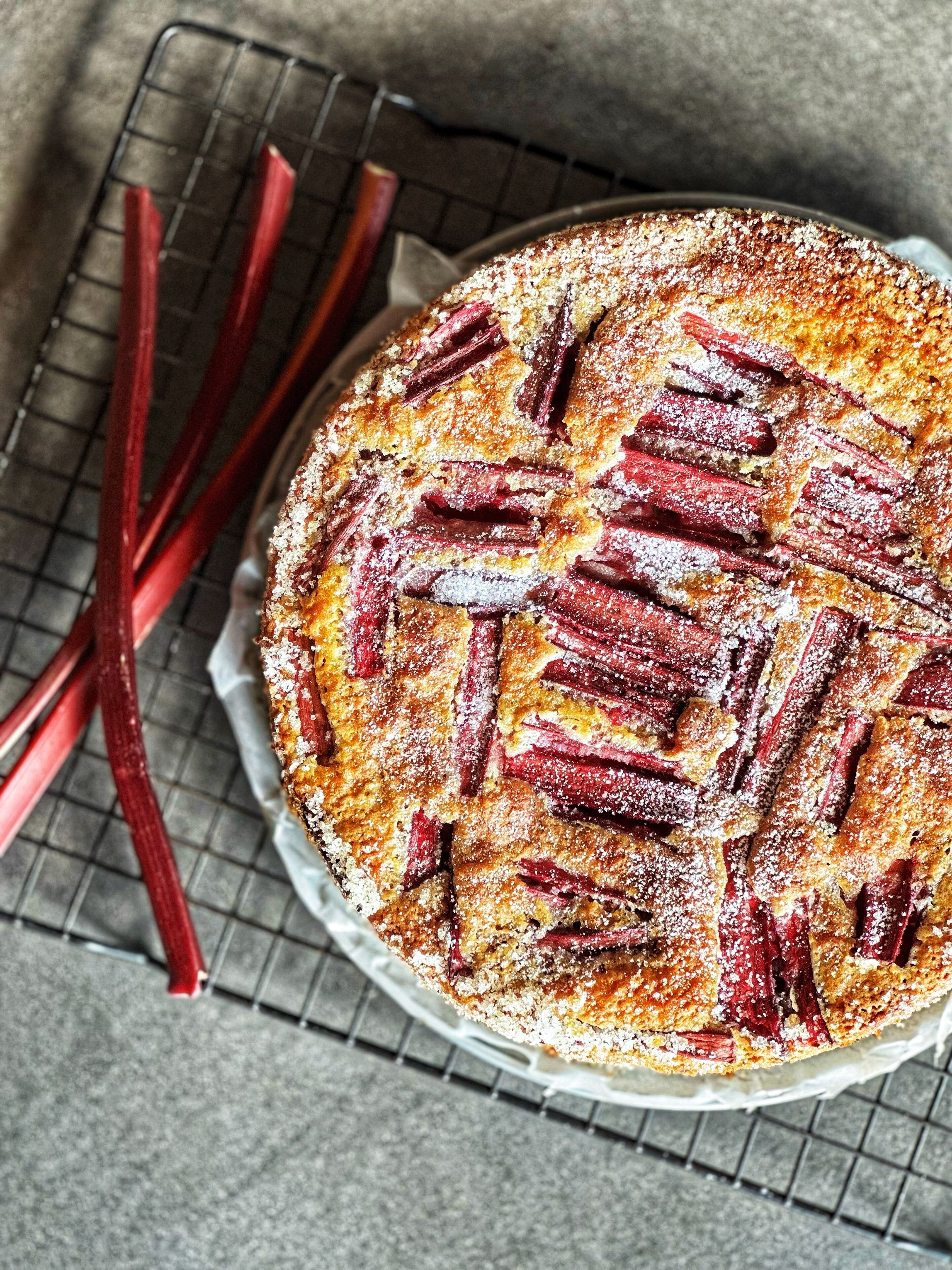 Une tarte aux fruits ronde, avec une pâte décorée en croisillons, posée sur une grille pour qu’elle refroidisse.