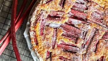 Une tarte aux fruits ronde, avec une pâte décorée en croisillons, posée sur une grille pour qu’elle refroidisse.
