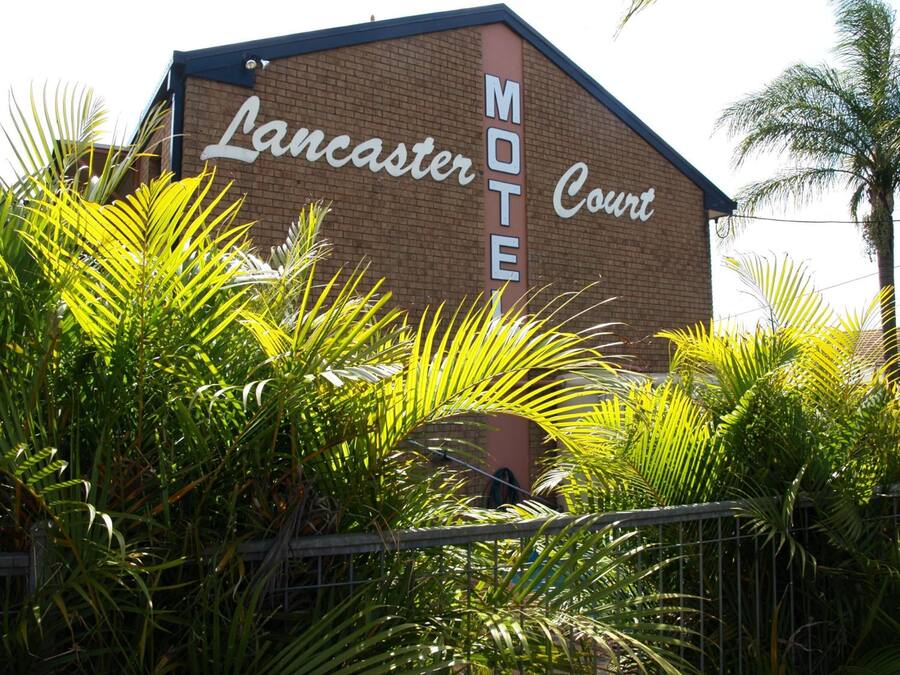 A brick building with a sign that reads "Lancaster MOT Court."