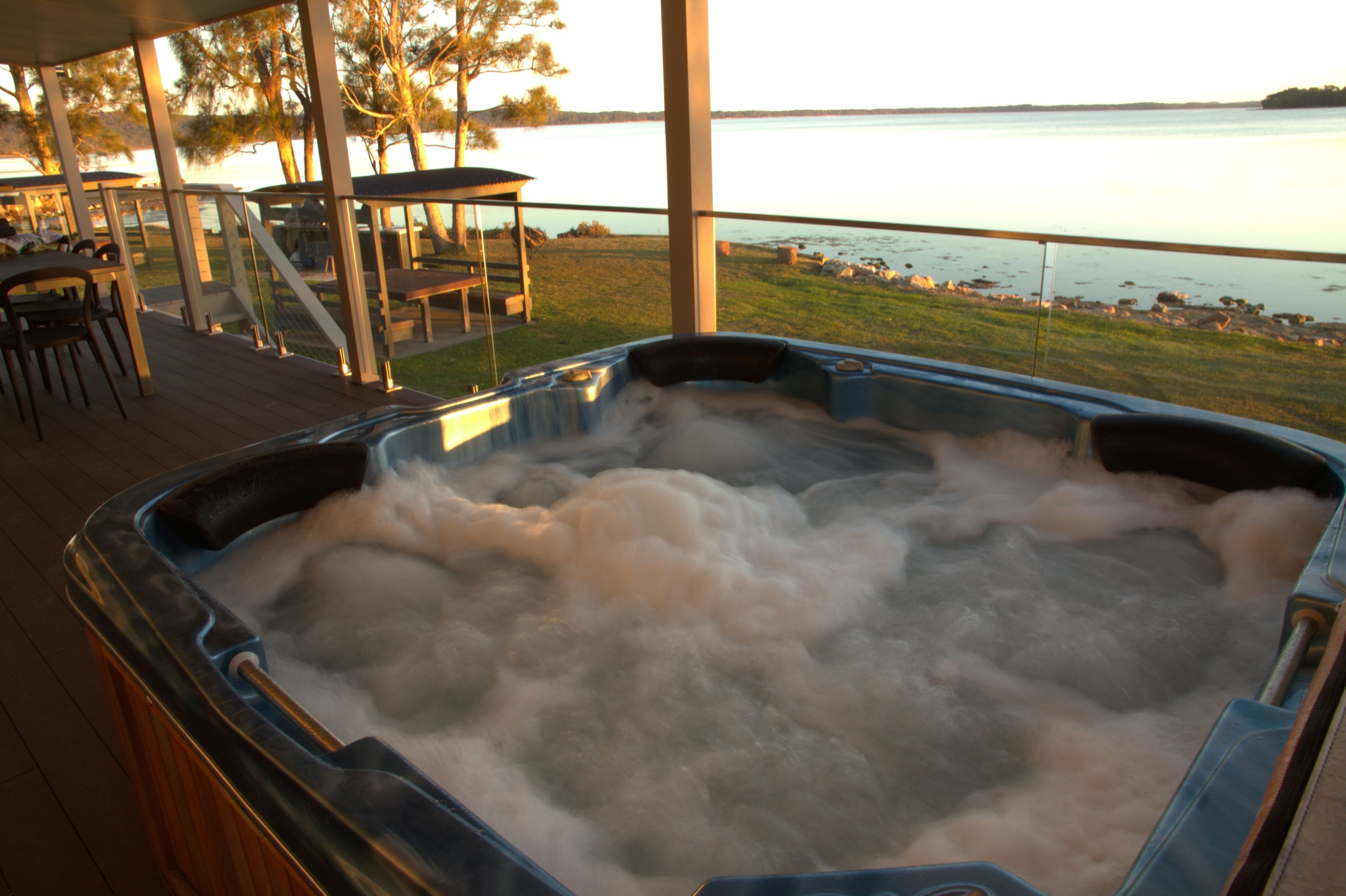 A hot tub with a view of a lake.