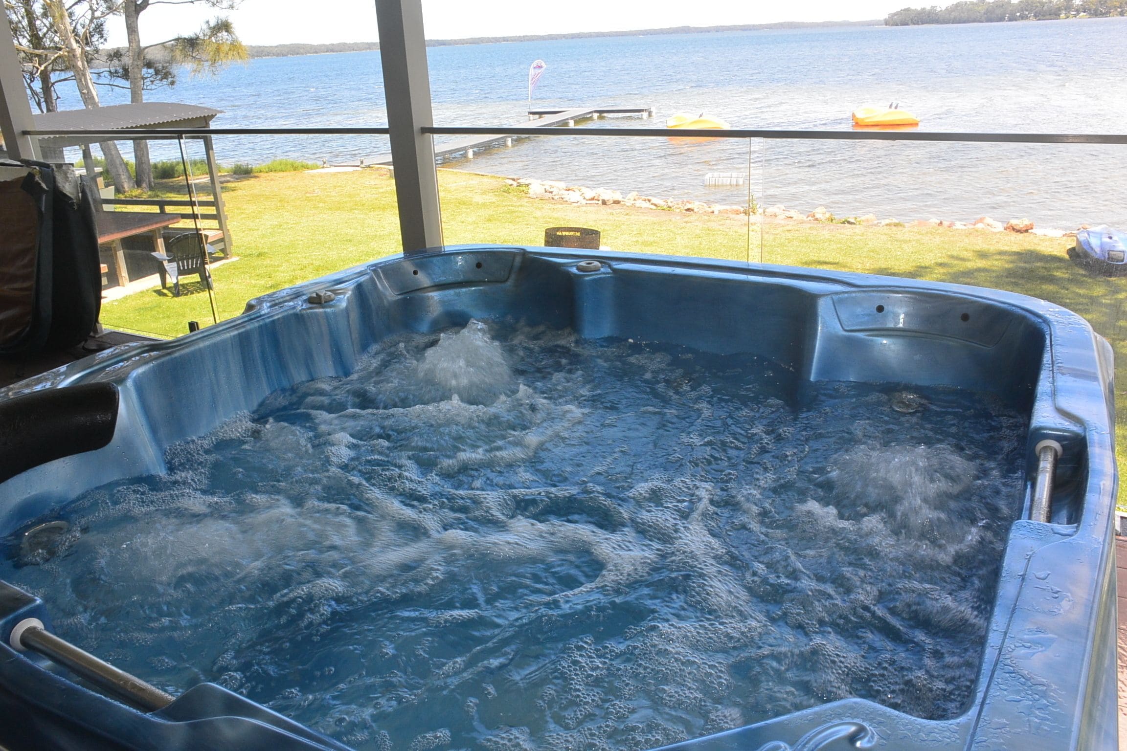 Un jacuzzi con vista a un lago y un muelle.