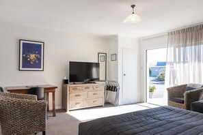 Una camera da letto con un letto, una TV, una scrivania e una sedia.