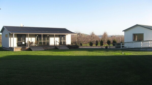 A two-story building with a covered porch and a satellite dish. - Bluebell Lodge And Cottage (Hastings)