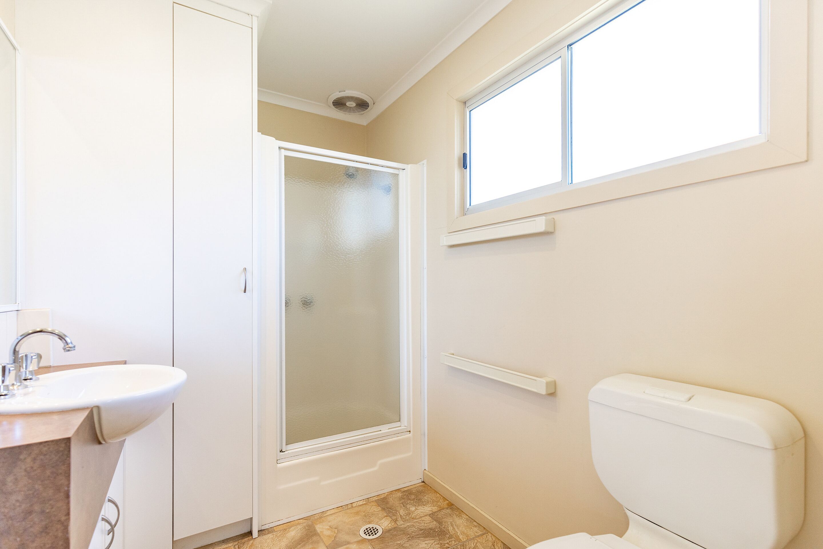 A bathroom with a shower, toilet, and sink.