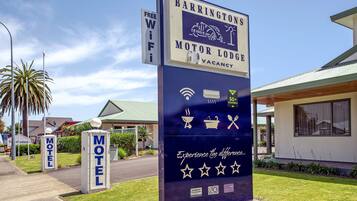 A motel sign with amenities like free WiFi, air conditioning, and a 50+ channel TV.