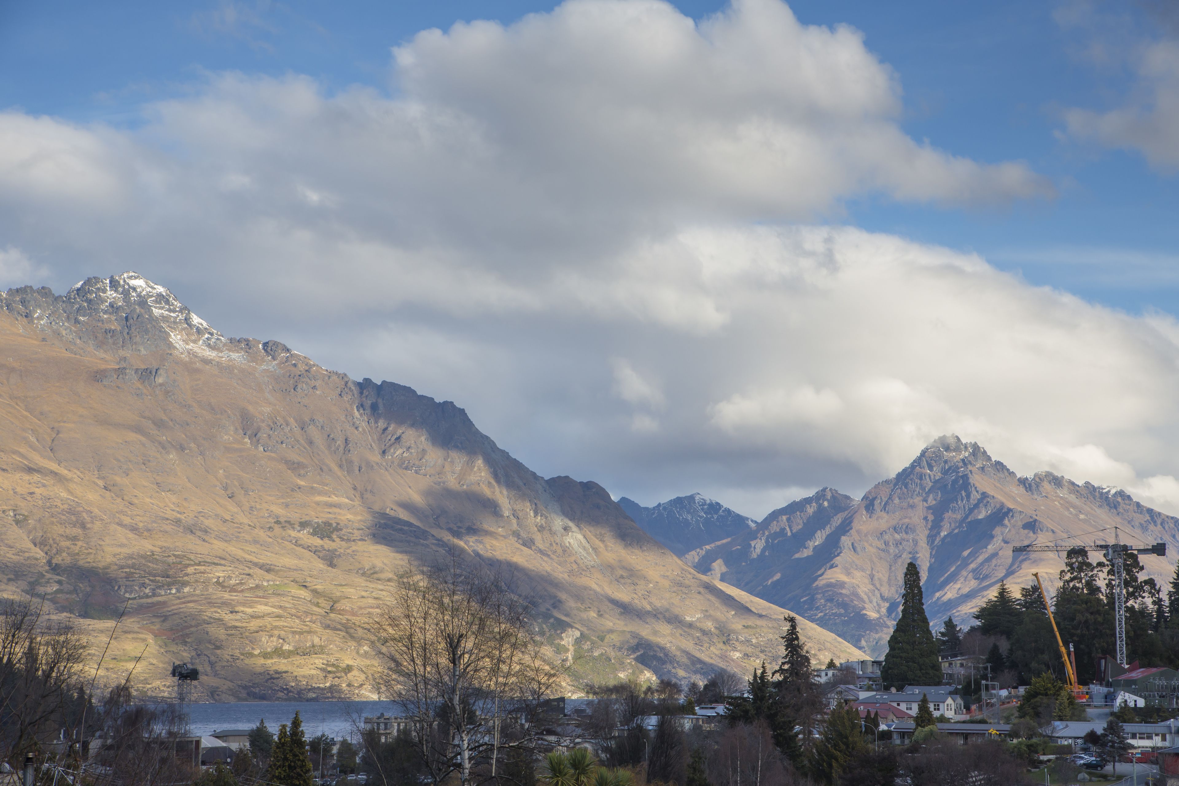 A mountainous landscape with a town in the foreground, featuring a mix of natural and man-made structures.