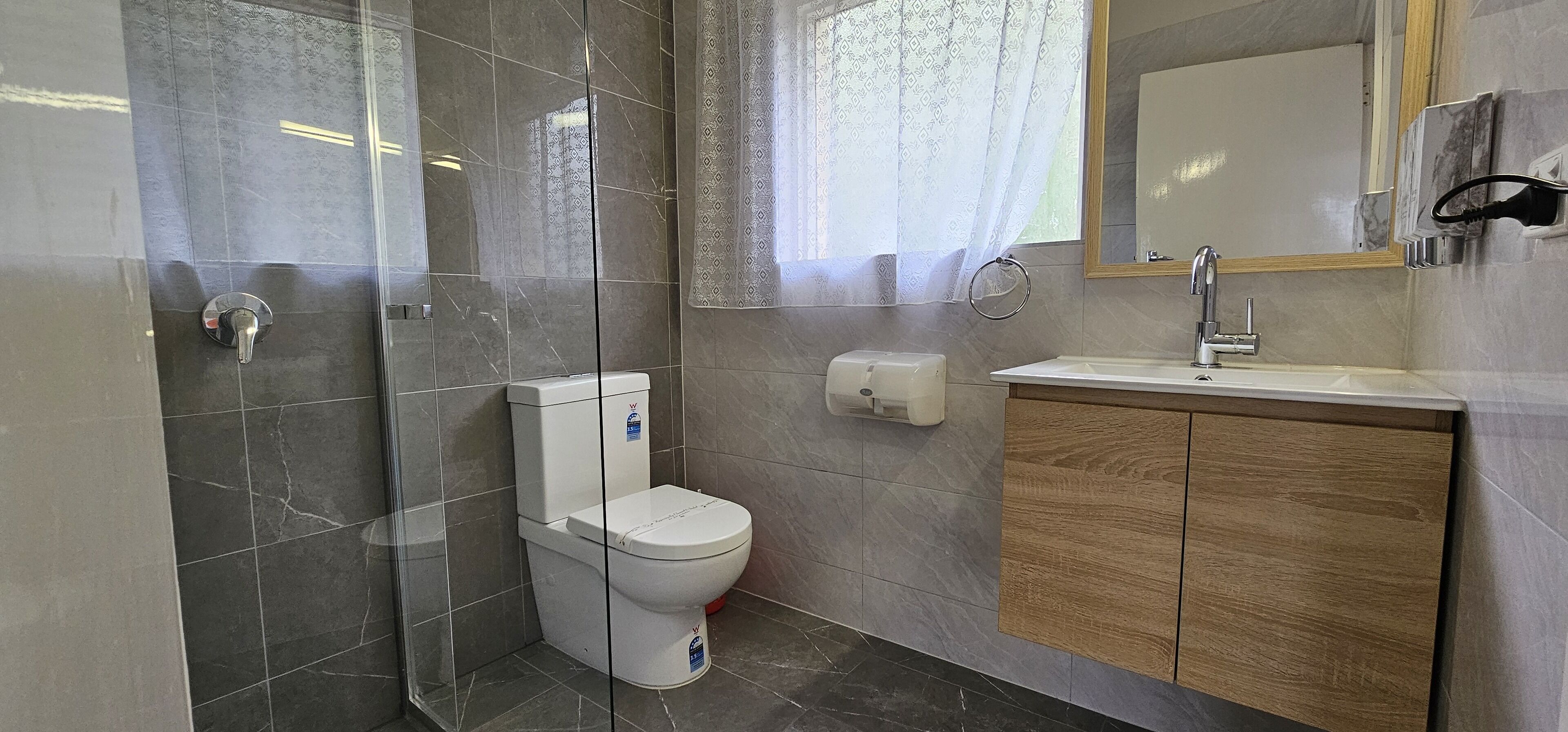 Un baño con inodoro, lavamanos y espejo.