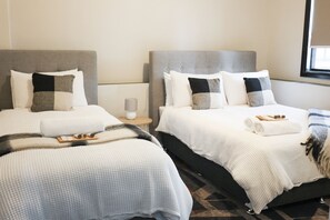 Escritorio, tabla de planchar con plancha y ropa de cama 