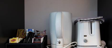A kitchen with a coffee maker and a toaster on the counter.