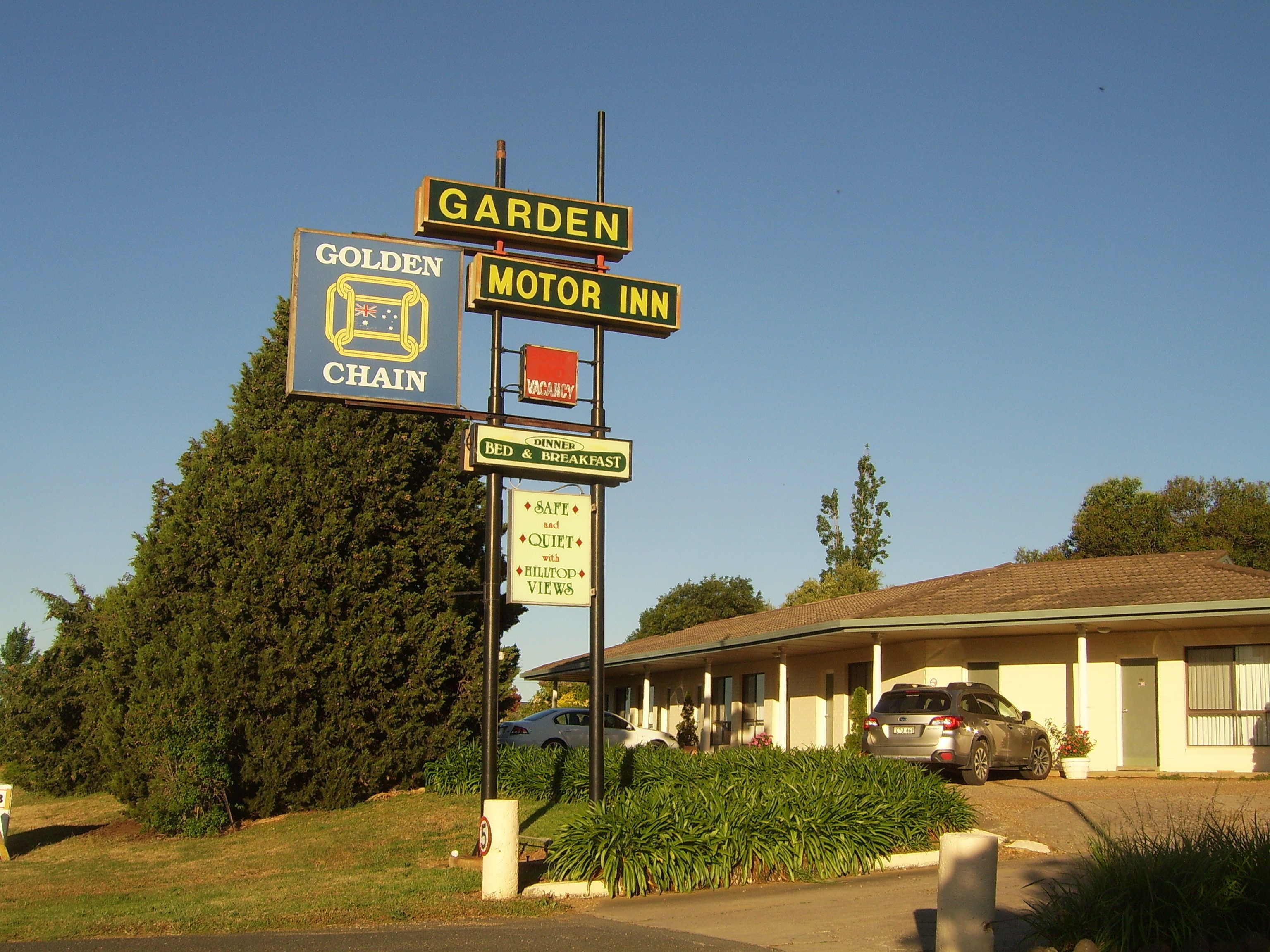 Letrero para un motel con jardín, hospedaje y desayuno, y un hotel Golden Chain.