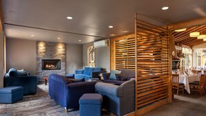 A modern living room with a stone fireplace, blue sofas, and a wooden partition. - Glen Erin At Lancefield - Vineyard Retreat (Lancefield)