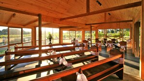 A wooden interior with benches and large windows offering views of a vineyard. - Glen Erin At Lancefield - Vineyard Retreat (Lancefield)