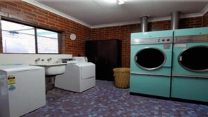Une buanderie équipée d’un lave-linge, d’un sèche-linge et d’un évier.