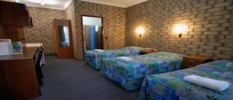 Habitación de hotel con dos camas, un escritorio y un espejo.