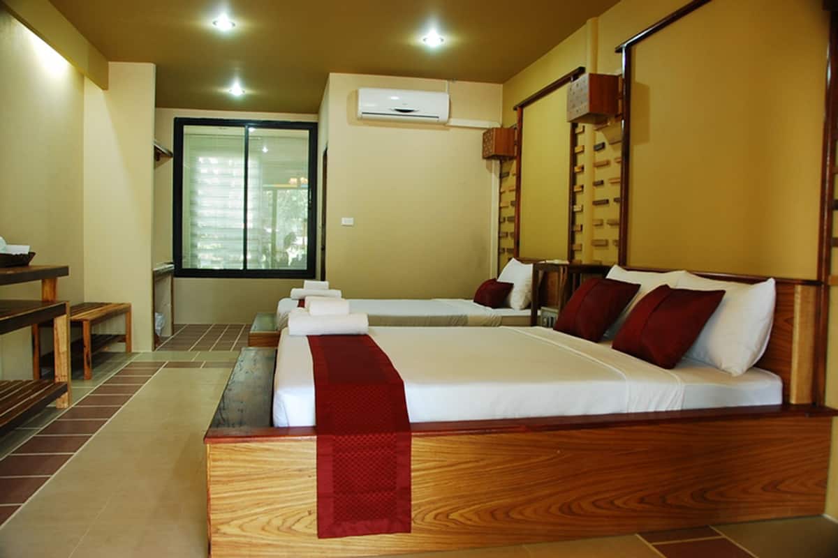 A hotel room with a large bed, a desk, and a window.