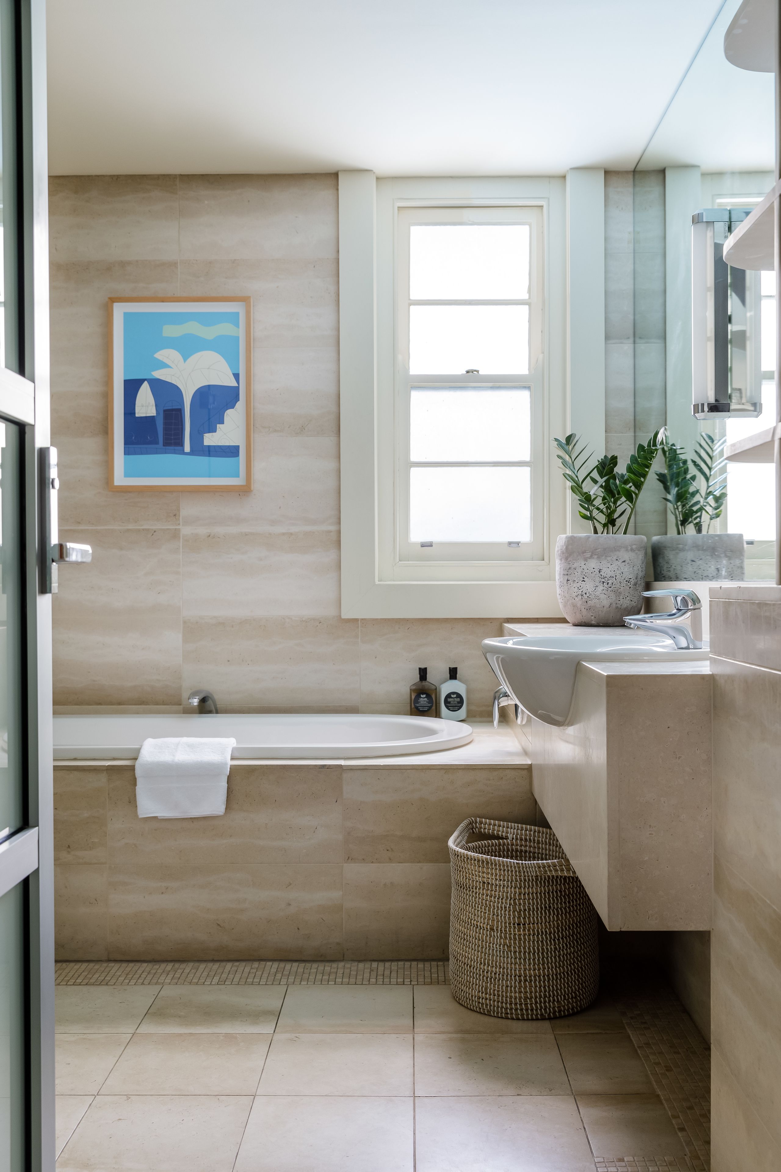 Un baño moderno con bañera, lavamanos y ventana.