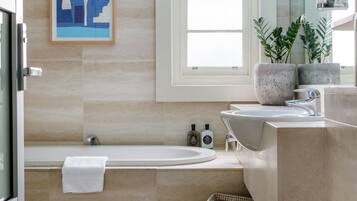 Un baño moderno con bañera, lavamanos y ventana.