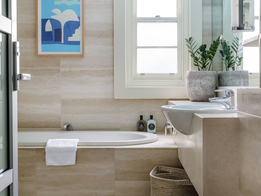 Un baño moderno con bañera, lavamanos y ventana.