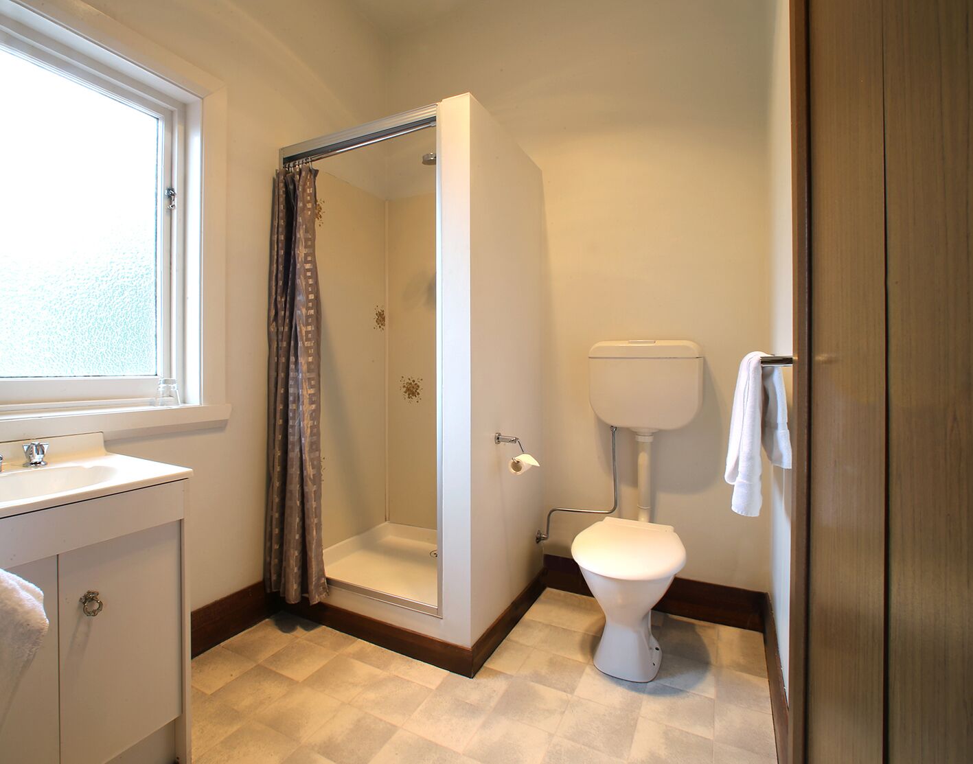 A bathroom with a shower, toilet, and sink.