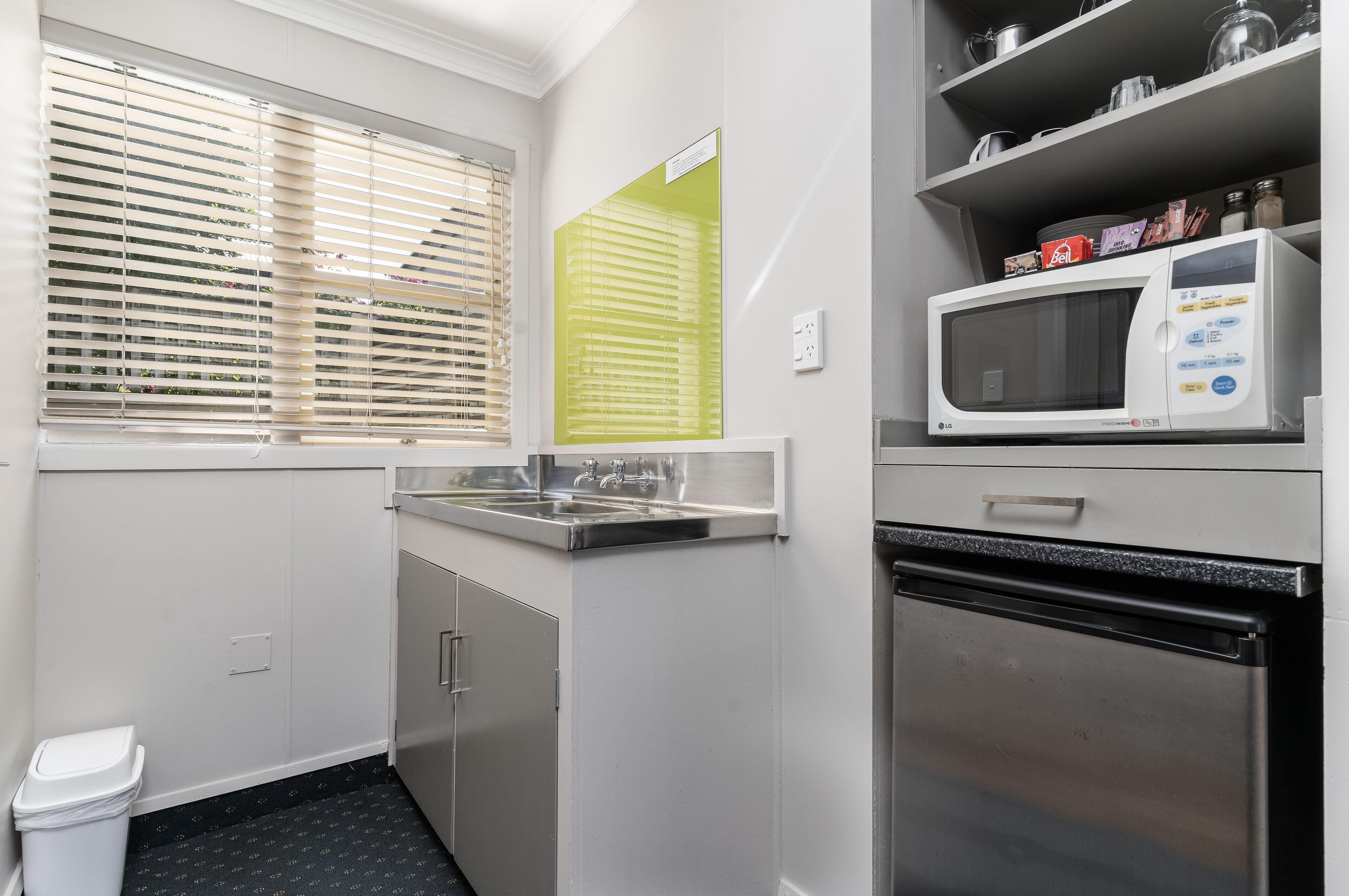A modern kitchen with a stainless steel refrigerator, a microwave, and a sink.