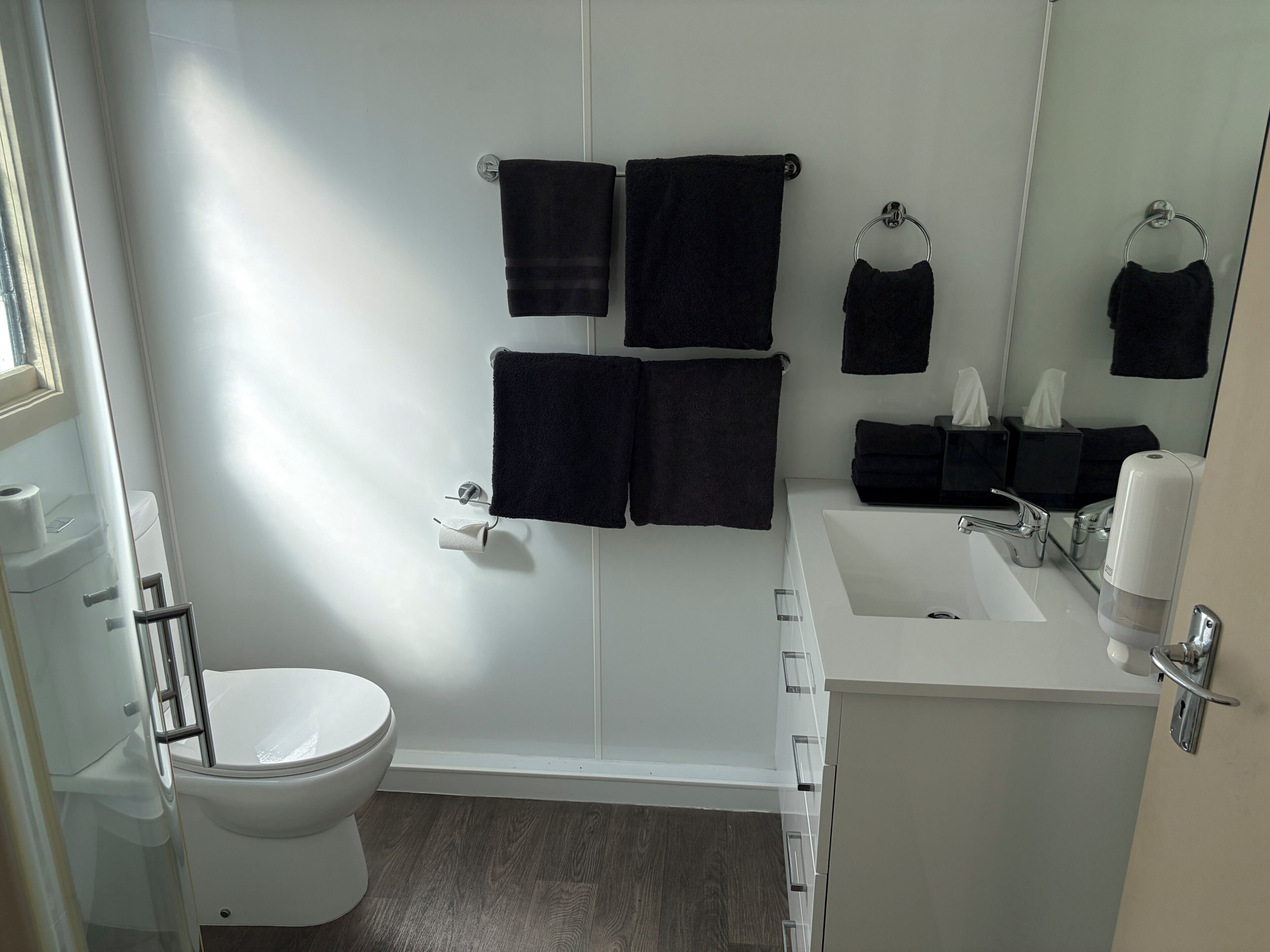 A bathroom with a toilet, a sink, and a mirror.