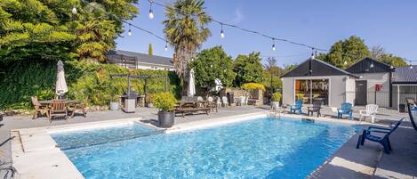 Una piscina al aire libre de temporada, sillones reclinables de piscina