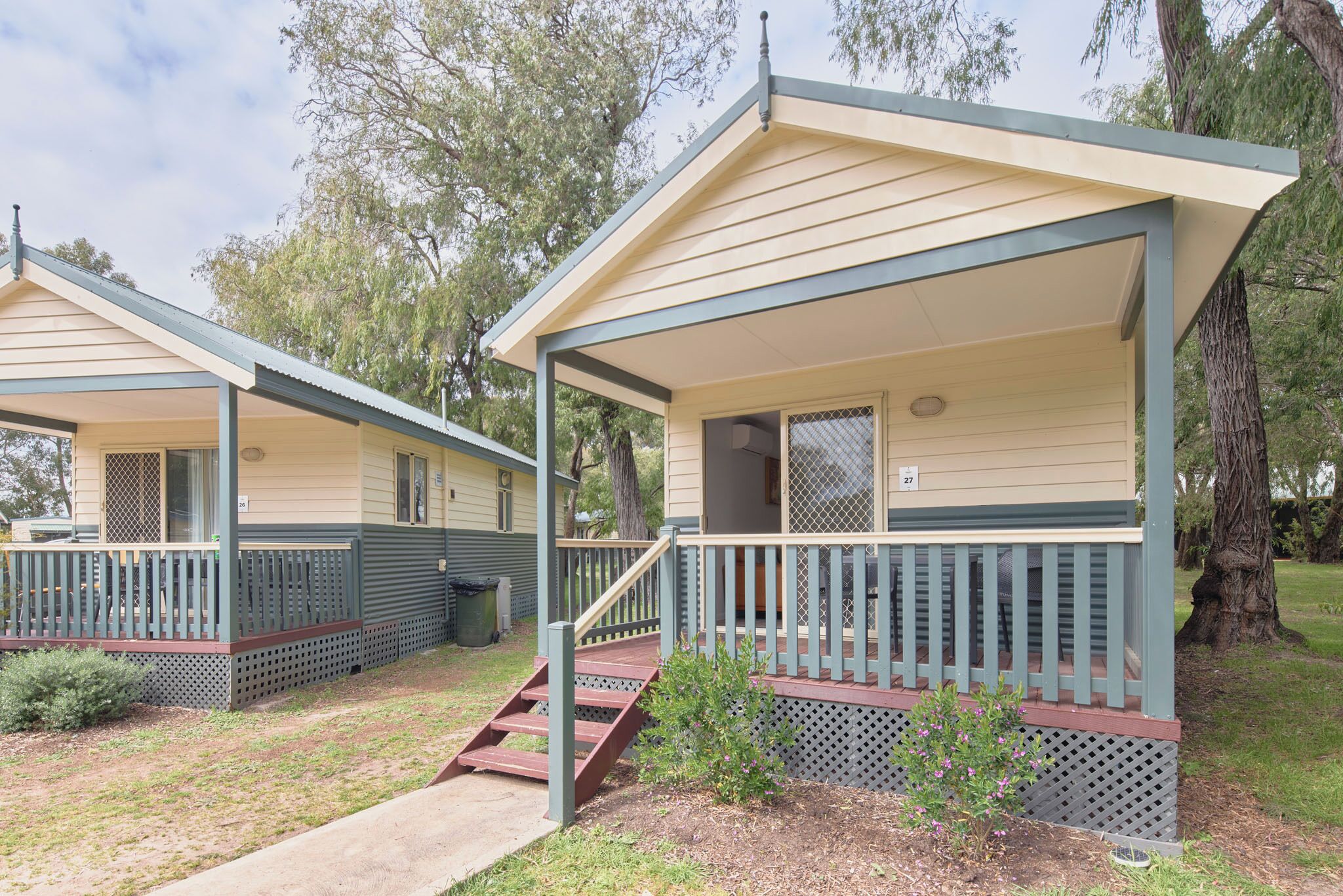 A row of two-story mobile homes with a porch and a small staircase leading to the entrance.