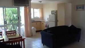 Un espacio habitable pequeño con comedor, kitchenette y sofá.