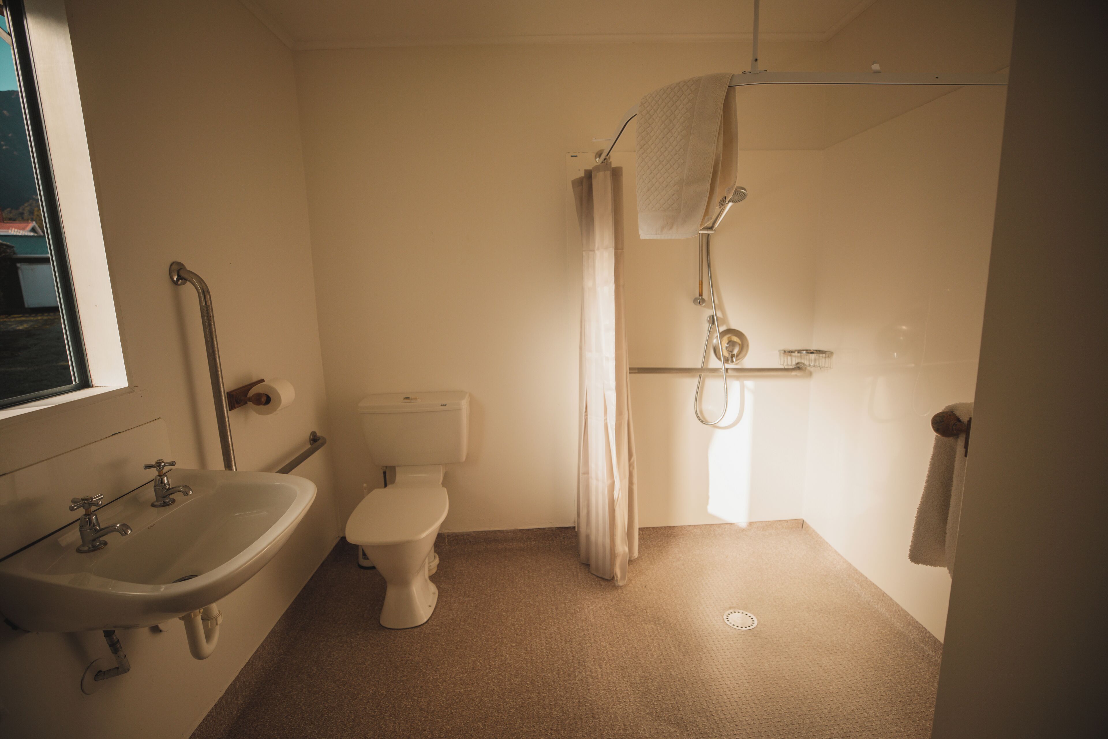 Un baño con lavamanos, inodoro y ducha.