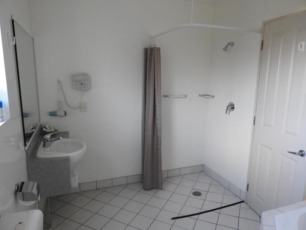 A bathroom with a shower, a sink, and a toilet.
