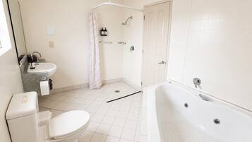 A modern bathroom with a toilet, sink, shower, and bathtub.
