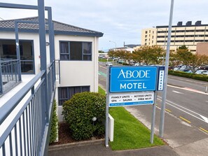 Une enseigne de motel indiquant les équipements disponibles, notamment des chambres familiales, des chambres accessibles aux personnes à mobilité réduite, un spa, un sauna et une connexion Wi-Fi gratuite.