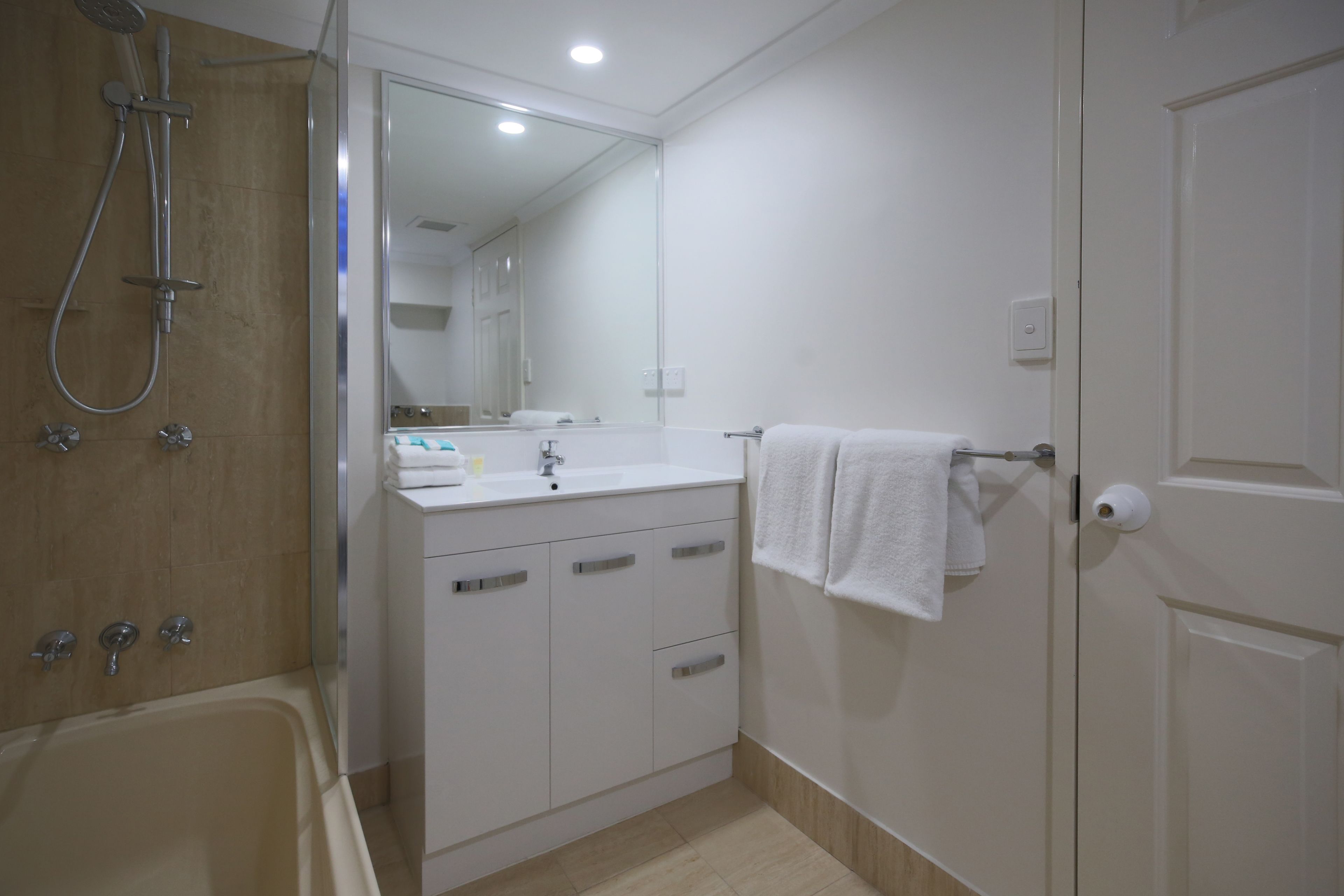 A modern bathroom with a bathtub, a sink, and a mirror.