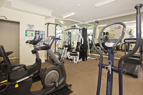 A gym with various exercise equipment including treadmills, elliptical machines, and weight machines. - 19th Avenue On The Beach (Palm Beach)