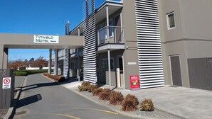 A modern building with a reception area, a sign for the Tinwald Motel, and a speed limit sign. - Tinwald Motels (Ashburton)