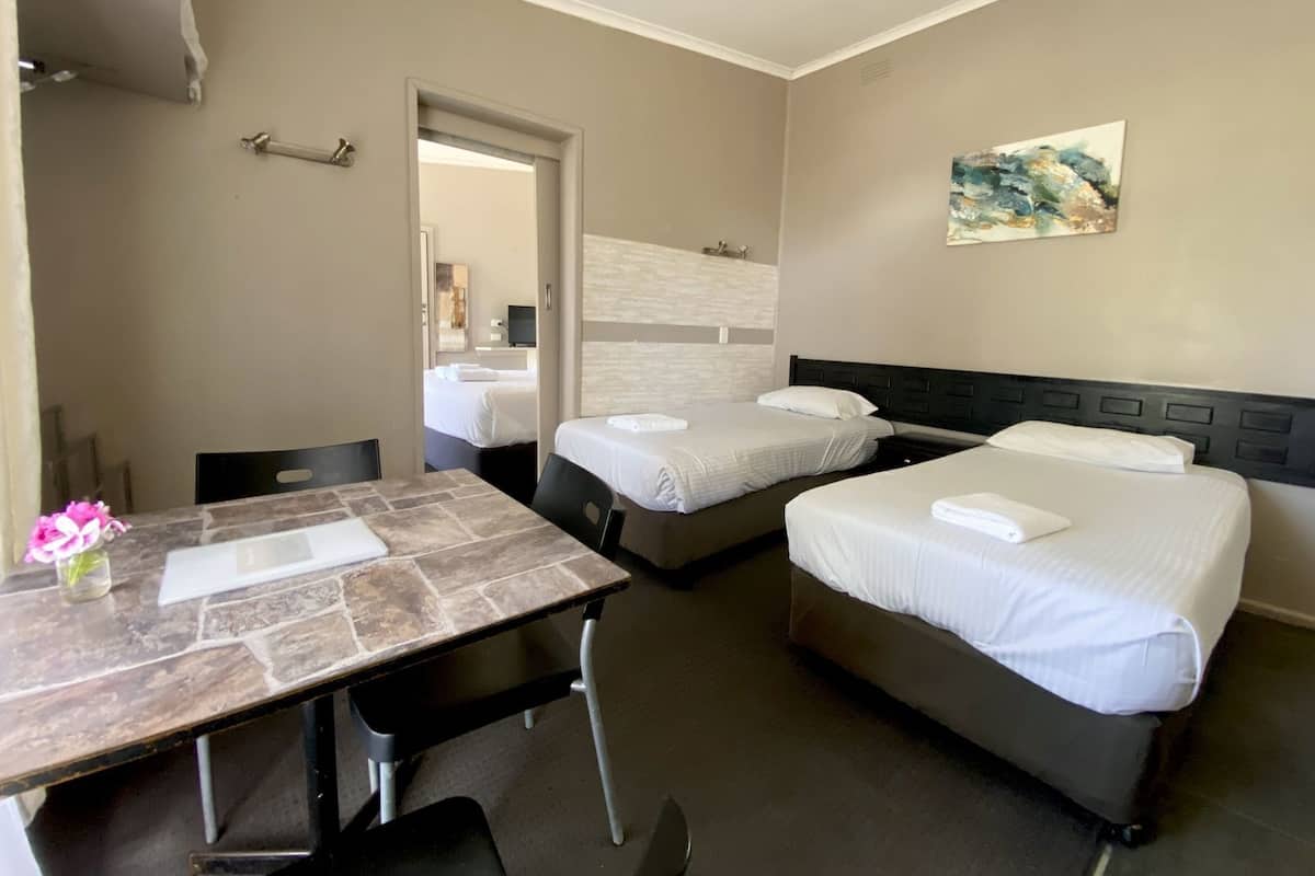Una habitación de hotel con dos camas, un escritorio y una silla.